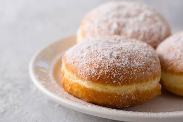 istock delicious donuts berliners with filling sprinkled with powdered sugar on a white plate 1480300661