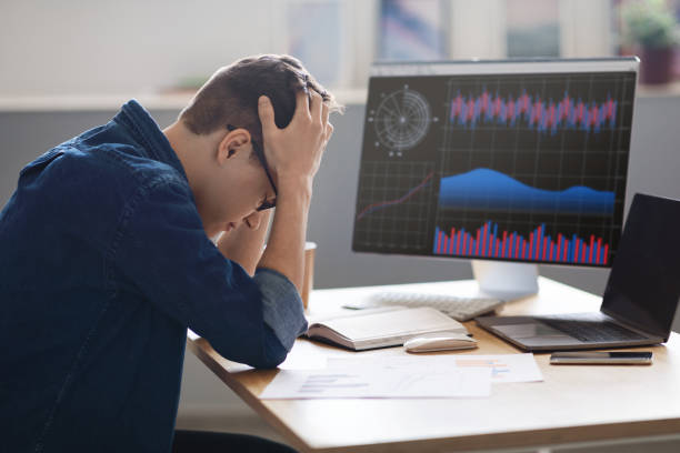 istock Crypto Crash. Depressed Young Male Employee Sitting At Workplace And Touching head 1480307790