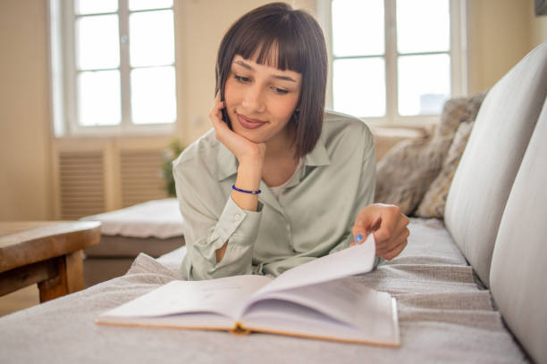 istock Woman reading book at home 1480308508