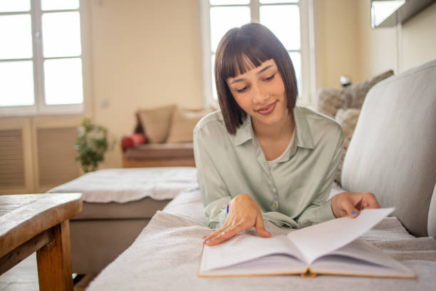 istock Woman reading book at home 1480308509