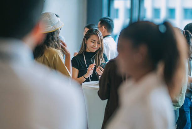 istock Asian Chinese female conference participant text messaging using smart phone during tea break 1480316982