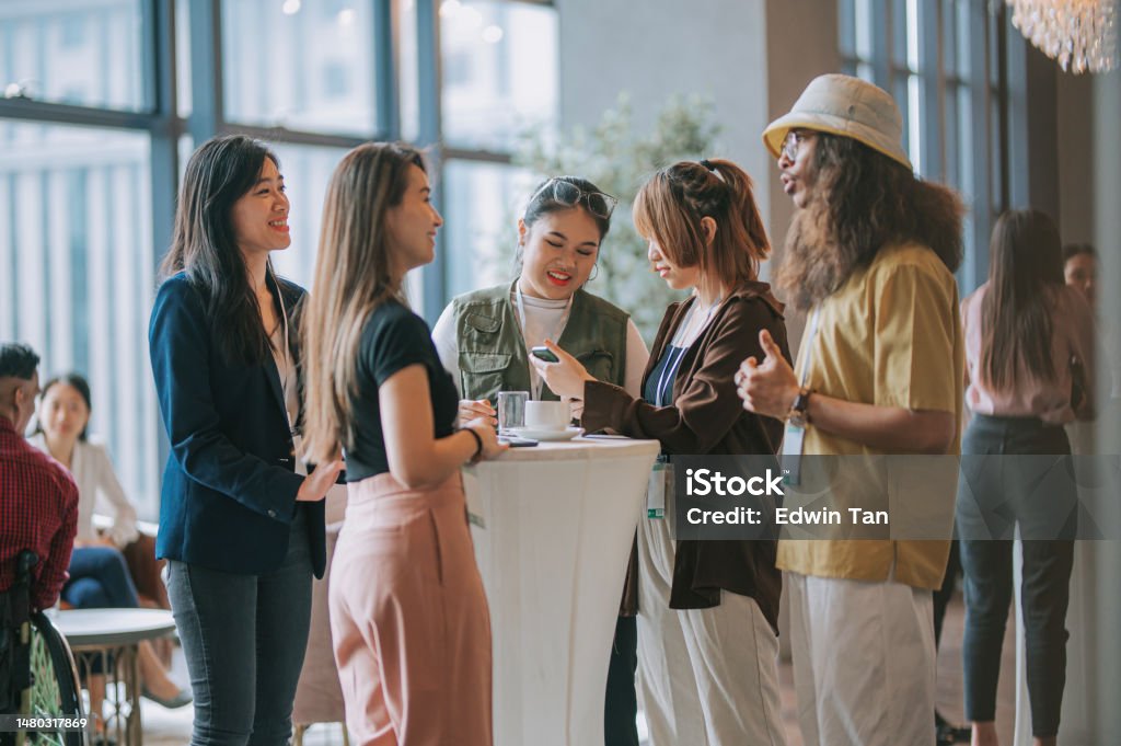 Asian young professionals having a casual chat after successful conference event Connection Stock Photo