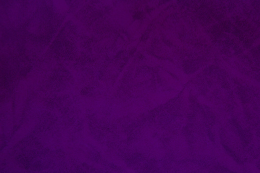 Texture of dark purple grained leather as a background. Natural material, top view.