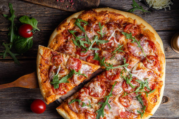 istock Appetizing pizza with ham on a wooden background 1480318310