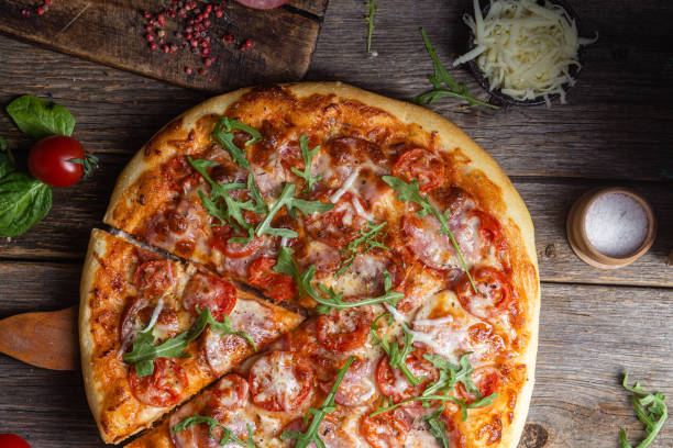 istock Appetizing pizza with ham on a wooden background 1480318943