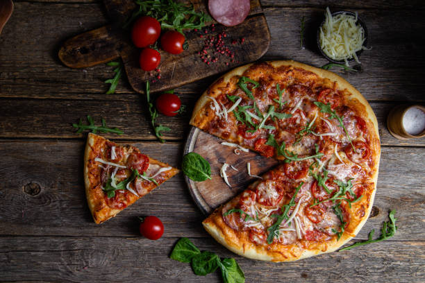 istock Appetizing pizza with ham on a wooden background 1480319563