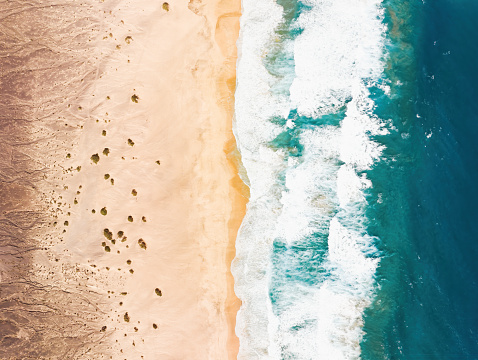 View from above, stunning aerial view of a beautiful beach bathed by a turquoise water. Cofete Beach (Playa de Cofete) Fuerteventura, Canary Islands, Spain.