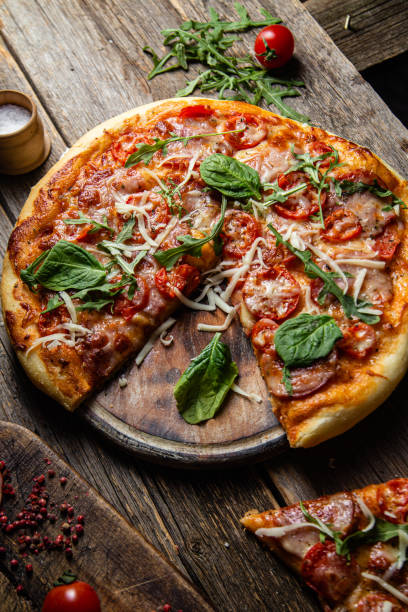 istock Appetizing pizza with ham on a wooden background 1480319898