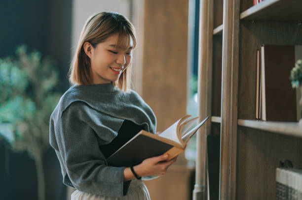 istock Asian Chinese young woman reading book at library 1480320326