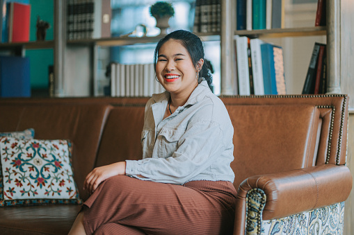 Indoor Portrait Asian Chinese young woman looking at camera smiling