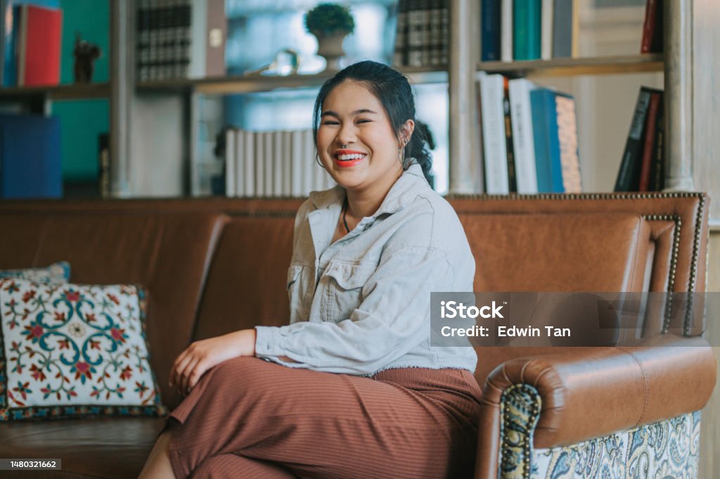 Indoor Portrait Asian Chinese young woman looking at camera smiling Resilience Stock Photo