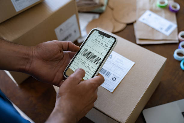 Close-up on an entrepreneur shipping some orders using a mobile app