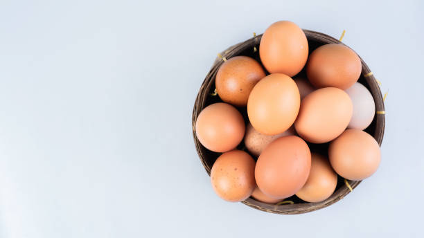 istock Whole chicken eggs in basket on white background, top view, copy space 1480325484