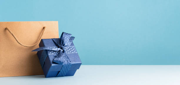 istock one gift box with a blue bow and paper bag on desk 1480327322