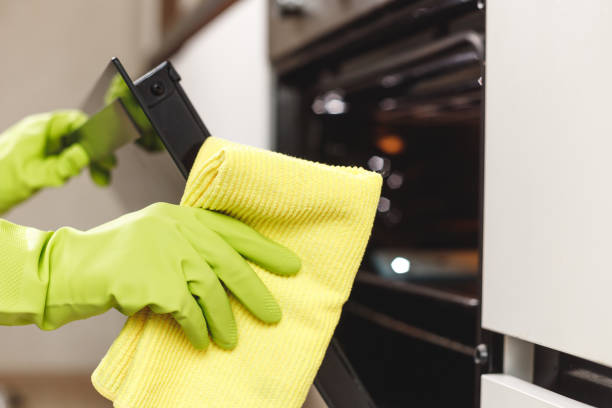 istock Hand in Green Glove Cleaning Kitchen Oven Door with Microfiber Rag. Doing Home Chores 1480329450