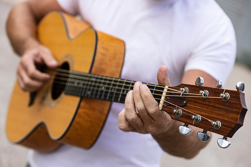 Acoustic Guitar Being Played by a man close up