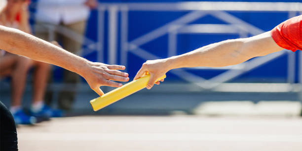 istock hand men passing baton running relay race in summer athletics championship 1480332497