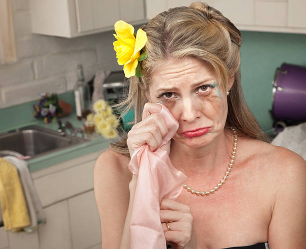 Crying Woman Caucasian housewife wipes tears with napkin in her kitchen retro 1950s kitchen stock pictures, royalty-free photos & images