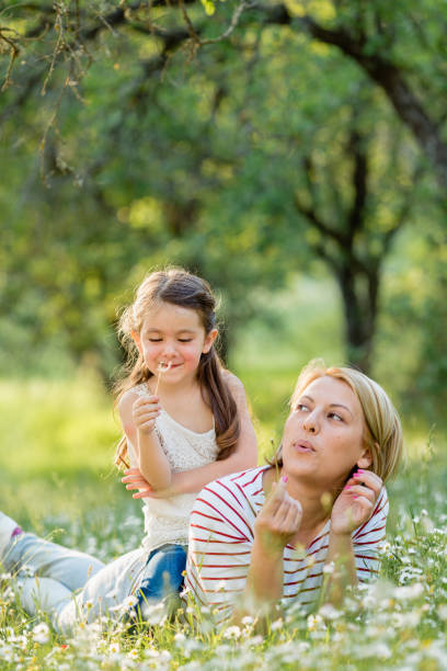 istock Mother and child having fun blowing dandelion seeds 1480338153