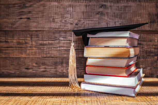 istock Academic cap and brown books on orange surface isolated on yellow 1480338909