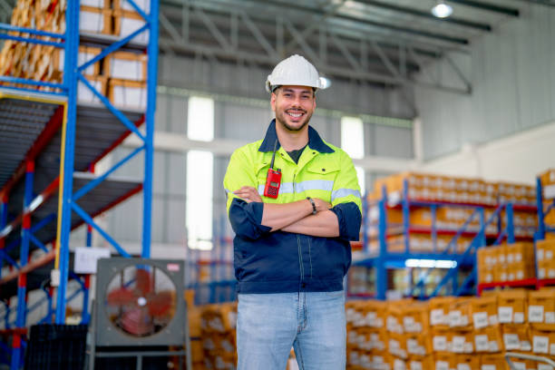 istock Professional warehouse worker stand with arm-crossed and smiling also look at camera stand in front of shelves with cardbox of product in workplace. 1480338921