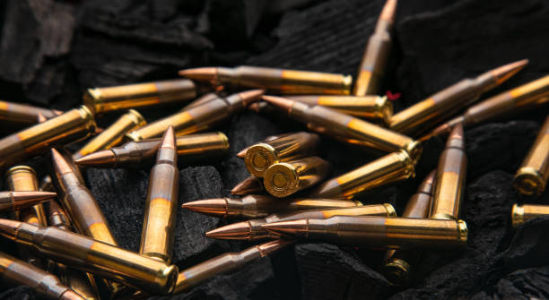 istock Cartridges for automatic carbine caliber .223 on charcoal. Ammunition for automatic and semi-automatic rifles. Dark background. 1480341217