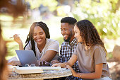 Students, friends and group studying with laptop at park outdoors. Education scholarship, learning teamwork and happy people, black man and women with computer for  research at university or college.