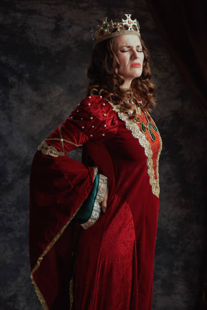istock tired medieval queen in red dress with crown having backache 1480343037