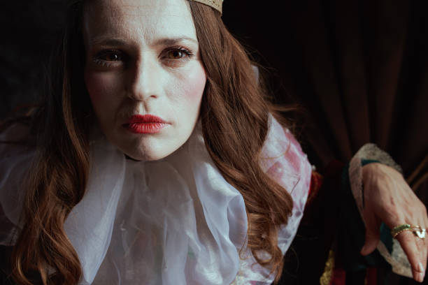 scary medieval queen in red dress with white collar on dark gray background.