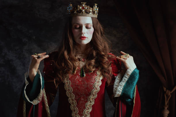 istock medieval queen in red dress with white makeup and crown 1480344032