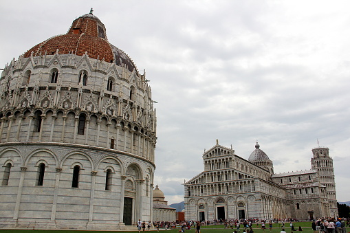 Baptistery of St. John, completed in 1363, in the Piazza dei Miracoli, view north-west toward the Cathedral and the Leaning Tower, in the background, Pisa, Italy