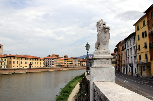 Lion holding a cartouche with Madonna and Child, stone carved classical sculpture on the embankment of Arno river, by the Solferino Bridge, Ponte Solferino, Pisa, Italy