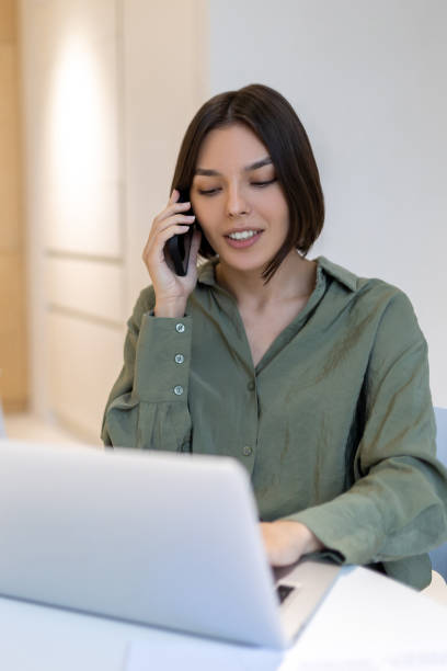 istock Corporate worker using her laptop during the phone conversation 1480345168