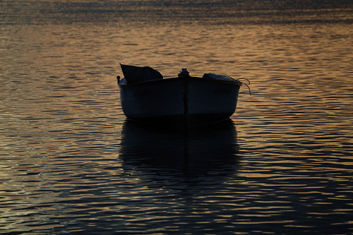 Albion, Mauritius - April 03, 2023: Silhouette of fishermen boat at the beach in the West of Mauritius during sunset.