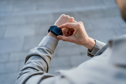 Man checking notification on his smartwatch outdoors