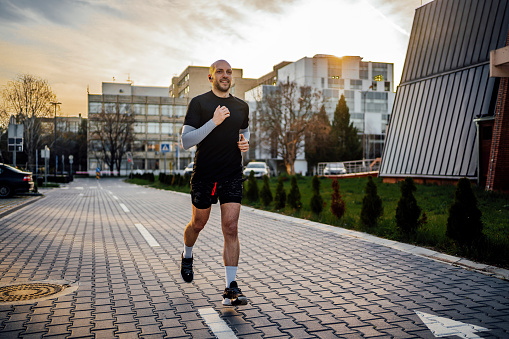 Young cheerful fitness man running outdoor