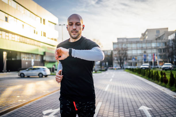 istock Man checks data on a fitness tracker while running 1480348983