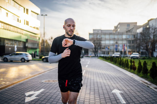 istock Man checks data on a fitness tracker while running 1480349015