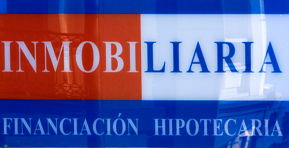 Real Estate office sign seen in the street. Mortgage financing. Galicia, Spain. Spanish language.
