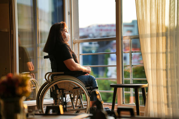 istock Disabled woman in a mask looking out at the scenery 1480353197