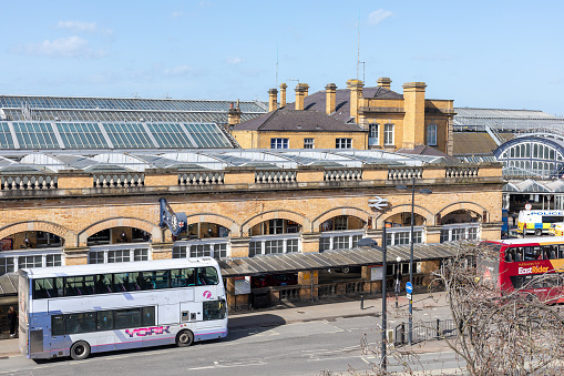 Exterior view of the architecture of the central main railway station at York in England UK. view shows station buildings, passengers and bus and travel connections
