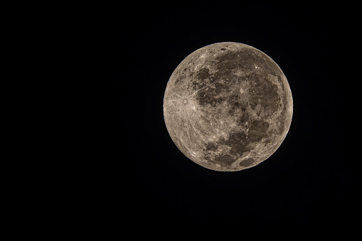 Full moon in the dark winter night with clearly visible moon surface during a partial eclipse in January 2020. Shot with a long telelens.