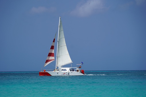 Eagle Beach Aruba March 2023- Tourists enjoy a sail in a catamaran in the beautiful clear turquoise water.