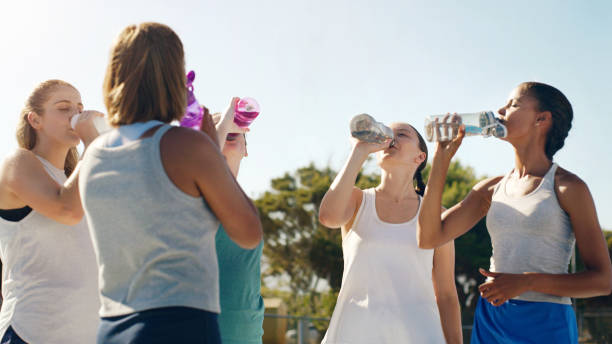 Athletic woman, friends and drinking water for hydration during sports workout, training or practice together outside. Group of sporty women staying hydrated for healthy sport exercise in nature mujer atlética, amigos y agua potable para hidratarse durante el entrenamiento deportivo, entrenamiento o practicar juntos al aire libre. grupo de mujeres deportistas que se mantienen hidratadas para hacer ejercicio deportivo saludable en la naturaleza