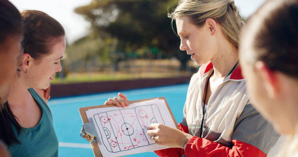 istock Planning, team and coach with a strategy for hockey, training plan and education on a game. Learning, coaching and woman teaching an idea for a sport competition on paper to girls on a court 1480358634