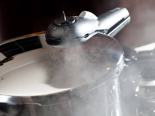 Steam escaping from new pressure cooker pot stock photo