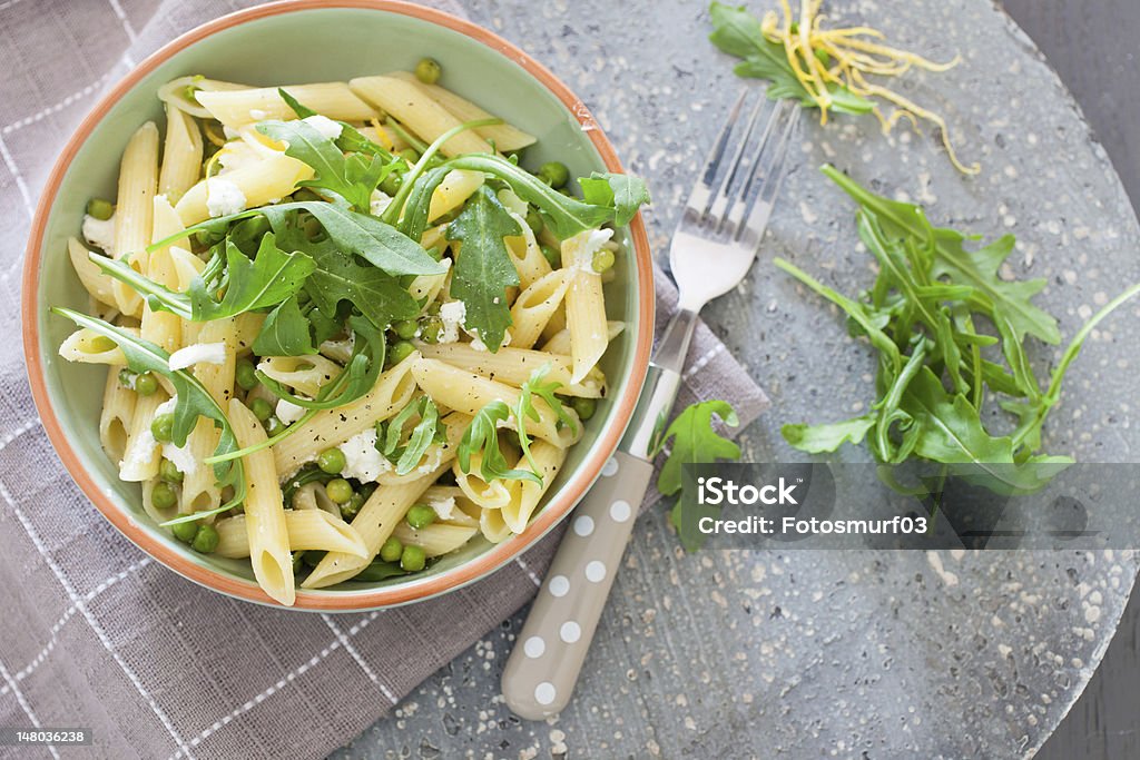 Pasta with goatcheese and rocket Healthy pasta dish with penne, goatcheese and rocket Arugula Stock Photo