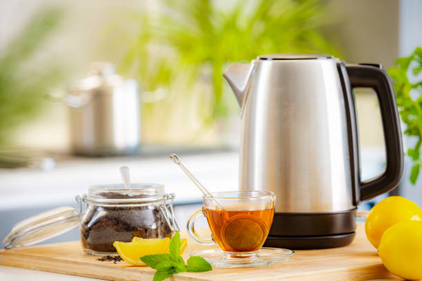 istock Cup of hot black tea and kettle on kitchen counter 1480365707