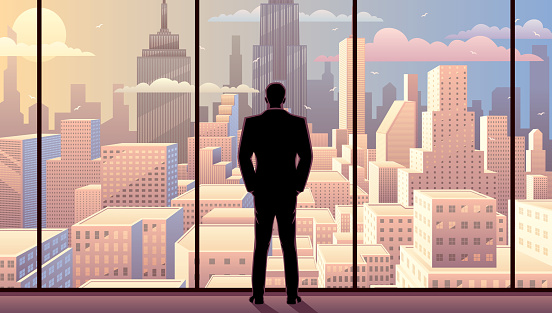 Businessman watching over the city from the window of his office.