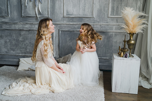 Girls in lace dresses playing in decorated room. Family weekend, beauty day, having fun, love concept.